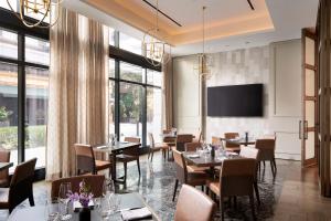 a restaurant with tables and chairs and a flat screen tv at Loews Coral Gables Hotel in Miami