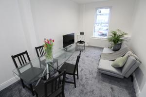 a living room with a glass table and a couch at Belfast Cozy Home in Belfast