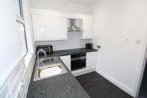 ベルファストにあるBelfast Cozy Homeのシンクと電子レンジのある小さなキッチン