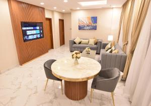 الدانة للشقق الفندقية في الكويت: غرفة معيشة مع طاولة وكراسي وأريكة