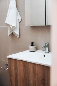 uma casa de banho com um lavatório branco e um espelho. em Indigo Seaside Experience em Adelianos Kampos