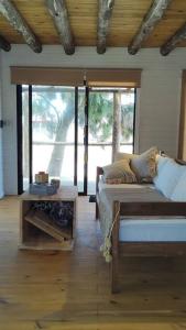 Sala de estar con cama y mesa en Juanillos cabaña con hogar a leña, en Punta del Diablo