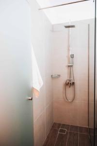 een badkamer met een douche en een glazen deur bij Indigo Seaside Experience in Adelianos Kampos