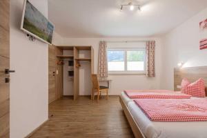 a bedroom with a bed and a desk and a window at Haus Jedeler in Neustift im Stubaital