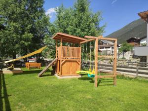 a wooden playground with a swing and a slide at Haus Jedeler in Neustift im Stubaital