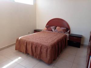 1 dormitorio con cama con colcha marrón. en Departamento Independiente en Tacna, en Tacna