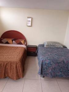 1 dormitorio con 2 camas y suelo de baldosa en Departamento Independiente en Tacna, en Tacna