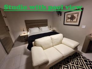 a bedroom with a white couch and a bed at Weston Guest House Krugersdorp in Krugersdorp