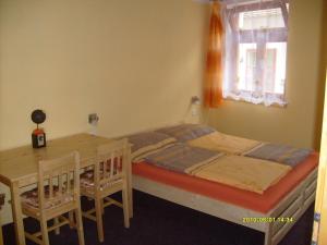 Rekreační dům Slavonice في سلافونيتسا: غرفة نوم بسرير وطاولة ونافذة