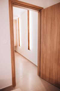 an open wooden door in a room with a white wall at Indigo Seaside Experience in Adelianos Kampos