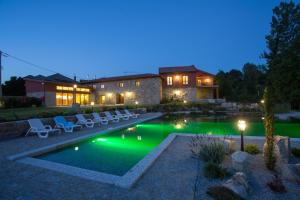 a house with a swimming pool in the yard at night at Quinta do Minhoto in Fafe