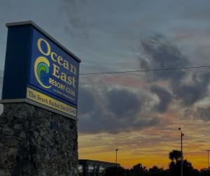 a sign for the ocean east resort club at sunset at Ocean East Resort Club in Ormond Beach