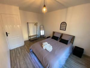 - une chambre avec un lit doté d'un peignoir blanc dans l'établissement Le Bill'ppart - Easy Life, à Bourgoin-Jallieu