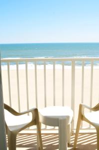 two chairs and a table on a balcony overlooking the beach at Dolphin Run in Virginia Beach