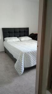 1 cama con cabecero negro en un dormitorio en Casa en Santa Marta en Santa Marta
