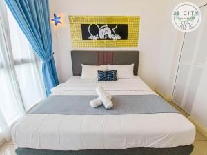 a bedroom with a bed with a teddy bear on it at D'Pristine Suites by JBcity Home in Nusajaya