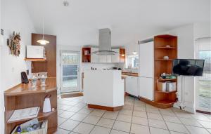 cocina con nevera blanca y TV en Holiday Home Tranebærvej Denm, en Hemmet