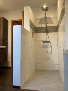 bagno con doccia e piastrelle bianche di Körners Ferienwohnung am Fuße des Voithenbergs a Furth im Wald Altre 20 foto