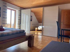1 dormitorio con 1 cama y puerta corredera de cristal en Körners Ferienwohnung am Fuße des Voithenbergs, en Furth im Wald