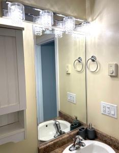 La salle de bains est pourvue de 2 lavabos et d'un grand miroir. dans l'établissement Sooke Vacation suite, à Sooke