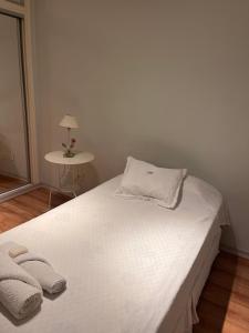 Una cama blanca con dos toallas encima. en OASIS Centro Obelisco en Buenos Aires
