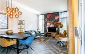 een woonkamer met een tafel en blauwe stoelen bij Nice Home In Voorthuizen With Kitchen in Voorthuizen