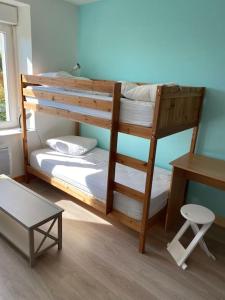 a bedroom with two bunk beds and a desk at Maison avec jardin in Crozon