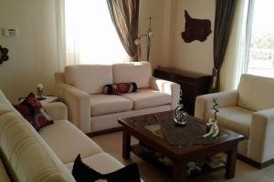 a living room with white couches and a coffee table at Rural 3-bedroom house Kalamata in Kalamata