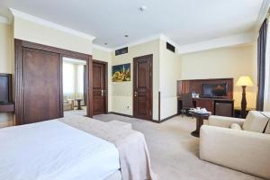 a bedroom with a bed and a couch and a television at Smith Hotel in Baku