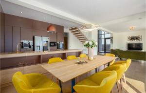 een keuken en eetkamer met een houten tafel en gele stoelen bij Amazing Home In Jesenice With Kitchen in Jesenice