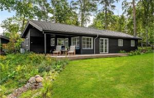 een zwart huisje met een patio en een tuin bij Lake Front Home In Gilleleje With Kitchen in Gilleleje