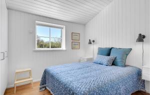 een slaapkamer met een bed met blauwe lakens en een raam bij Lake Front Home In Gilleleje With Kitchen in Gilleleje