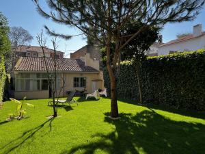 a green yard with a fence and a house at Cascais center House with garden in Cascais