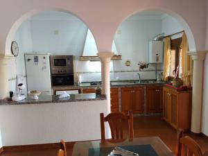 una cucina con arco e tavolo in una stanza di Villa Atlaymar a Barbate