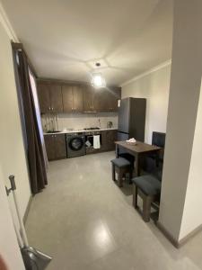 eine kleine Küche mit einem Tisch und einem Kühlschrank in der Unterkunft 3 Cosy apartment near Airport EVN in Yerevan