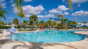 einen Pool in einem Resort mit einer Wasserrutsche in der Unterkunft Exquisite Home near Disney Themed Rooms & Home Theater by Rentyl - 7736F in Orlando