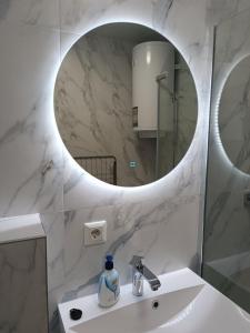 W łazience znajduje się umywalka i lustro. w obiekcie Квартира на двох, в центрі міста w mieście Mukaczewo