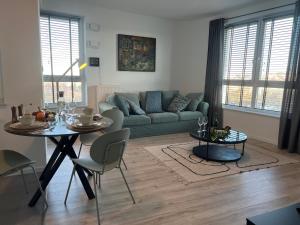 a living room with a green couch and a table at Modern Vero Apartments Górskiego in Gdynia