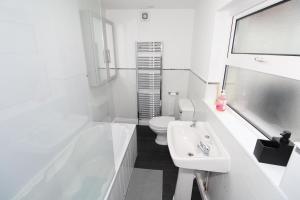 a white bathroom with a sink and a toilet at Belfast Cozy Home in Belfast