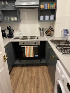 a kitchen with a stove and a sink at Stunning Studio Flat - Free Parking - 3 min from Sutton Station in Sutton