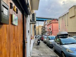 uma rua com carros estacionados ao lado de um edifício em SWEET DREAMS em Nápoles
