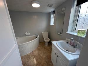 a bathroom with a tub and a toilet and a sink at Number 2 Seafield - sleeps 5 - Grantham town in Lincolnshire