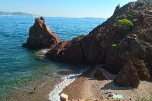 - une plage avec des rochers dans l'eau dans l'établissement 2 pièces climatisé à 200m des plages, à Théoule-sur-Mer