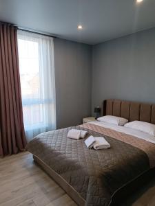 1 Schlafzimmer mit 2 Betten und einem großen Fenster in der Unterkunft Стильна квартира, центр Мукачева in Mukatschewo