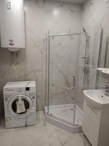 ein Bad mit einer Dusche und einer Waschmaschine in der Unterkunft Стильна квартира, центр Мукачева in Mukatschewo