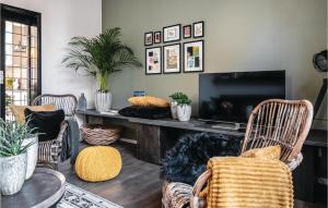 een woonkamer met een televisie en 2 stoelen bij Amazing Home In Ijzendijke With 3 Bedrooms And Wifi in IJzendijke