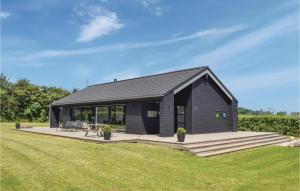 una casa negra con una terraza y un campo de césped en Stunning Home In Humble With Kitchen, en Humble