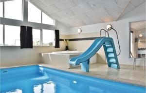 baño con piscina con tobogán azul en Stunning Home In Ringkbing With Sauna, en Klegod