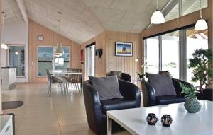 a living room with chairs and a table and a dining room at Amazing Home In Ringkbing With 8 Bedrooms, Sauna And Wifi in Klegod