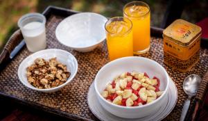 a table with a bowl of fruit and some drinks at Baan Manali Resort in Thongsala
